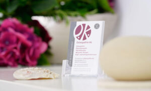 Imagefoto mit einer Visitenkarte der Praxis und einem Stein auf einem Tisch in einem Behandlungsraum