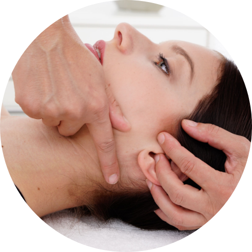 Foto einer beispielhaften Kopf-und Kiefergelenkbehandlung am Kiefergelenk einer Frau