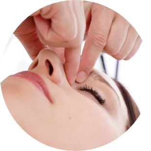 Foto einer beispielhaften Kopf-und Kiefergelenkbehandlung an der oberen Nasenwurzel einer Frau