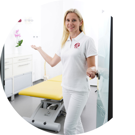 Foto von Frau Anett Hörster, die Patientinnen und Patienten begrüßt und die Tür zu einem Behandlungsraum öffnet